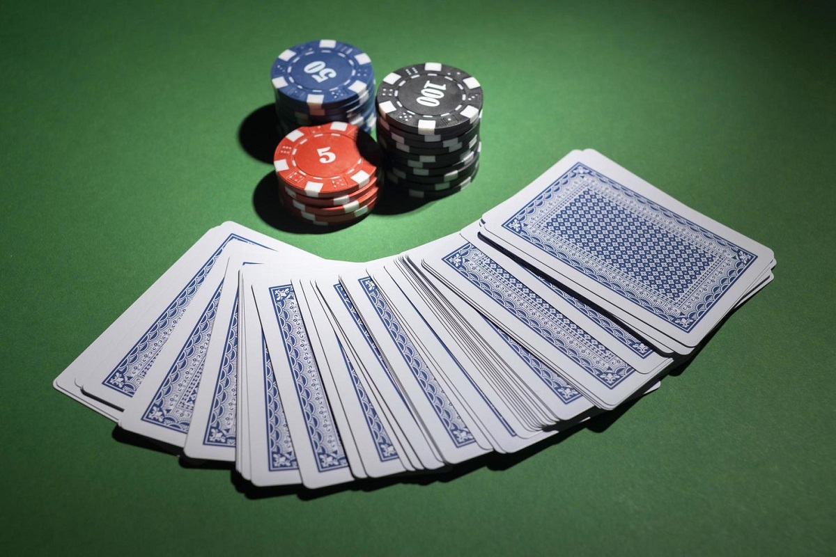 casino-tokens-on-green-background-with-deck-of-cards-free-photo